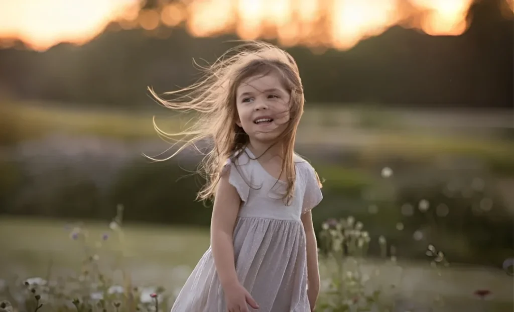 Japanese Girl Names that Mean Wind -- a little girl standing in a field while wind stirs her hair