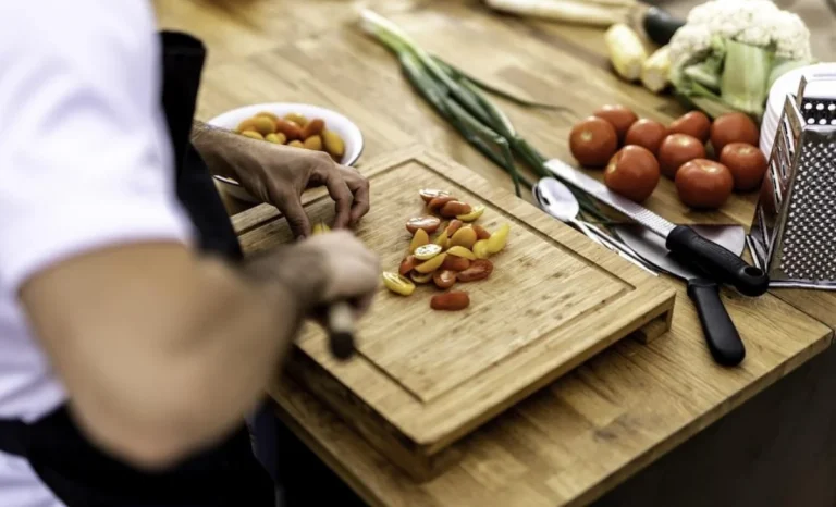 a chef man cutting tomatoes