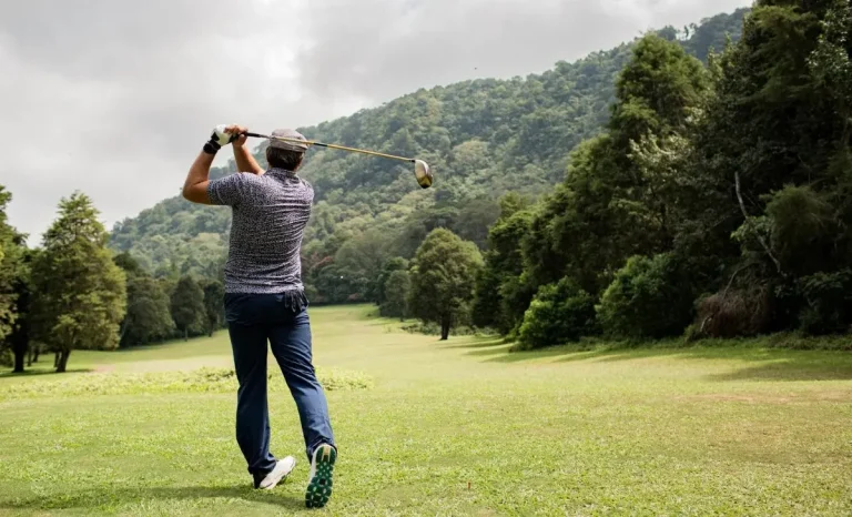 a man hitting a golf ball with tee