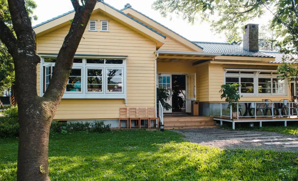 a yellow house with wooden windows