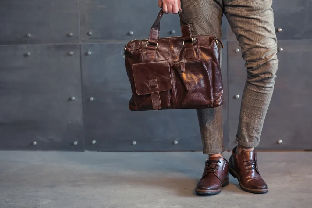 a man holding a leather tote bag