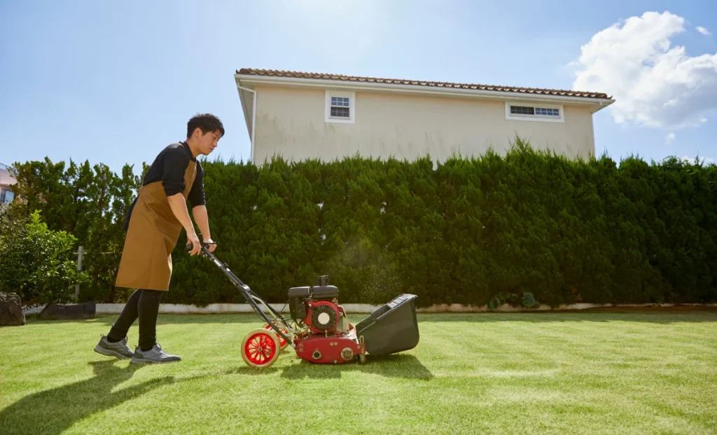 a man using electric lawn mower