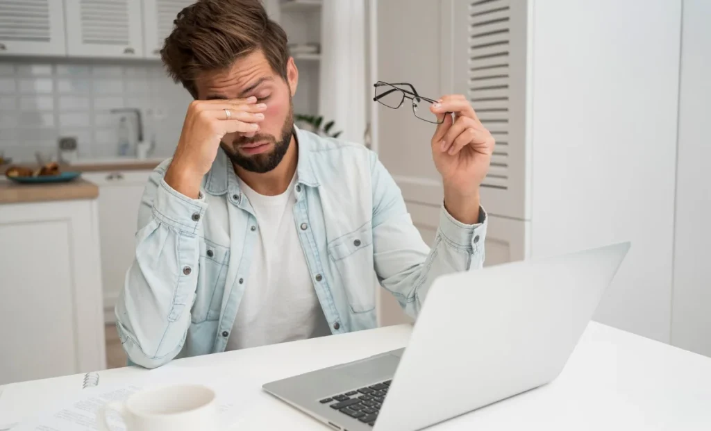 a tired employee rubbing his eyes