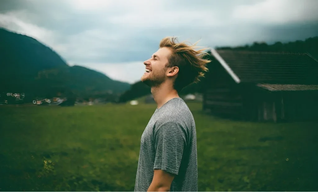 a traveler man enjoying the wind in an field