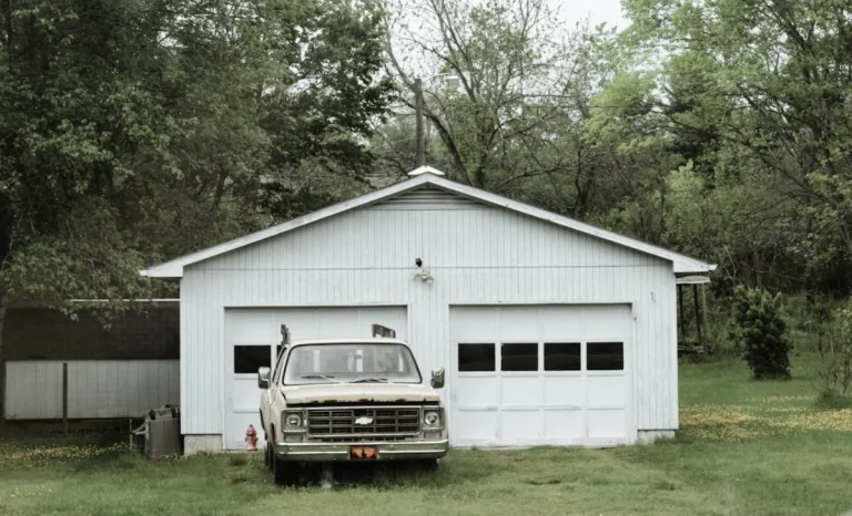 an old car parked near a garage