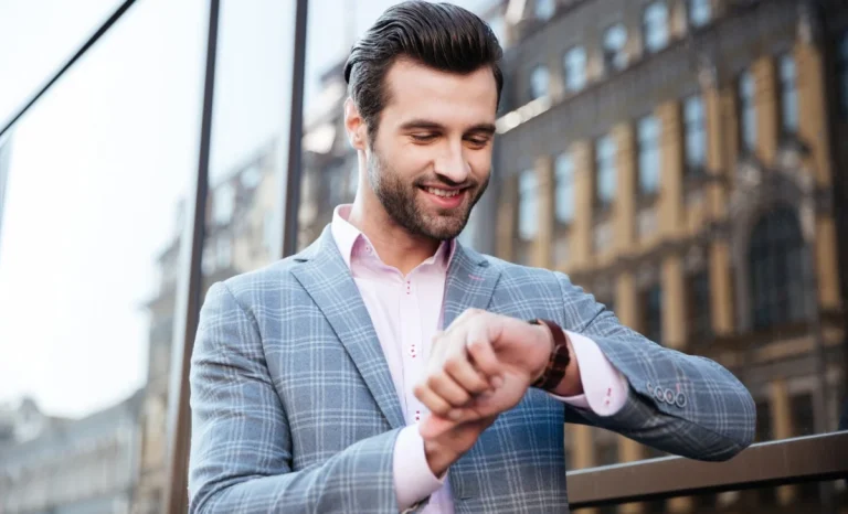 a man smiling and looking at his watch