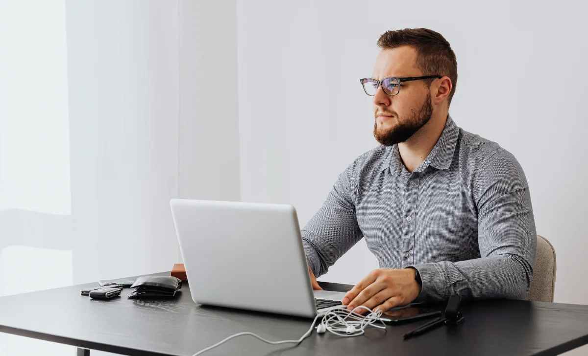 a man with glasses using a laptop