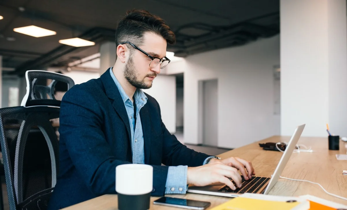 young man working on laptop in an office