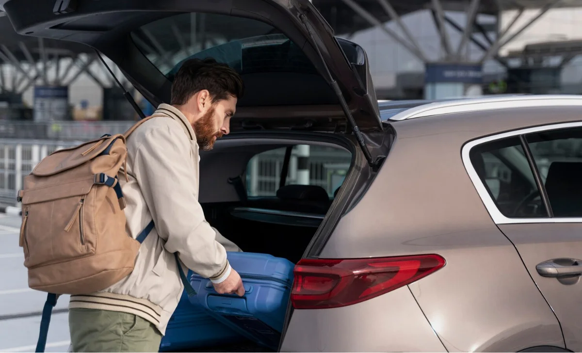 a man putting bags into the back of the car
