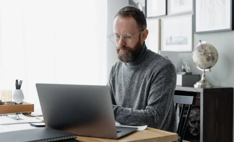 a man wearing glasses working in a office