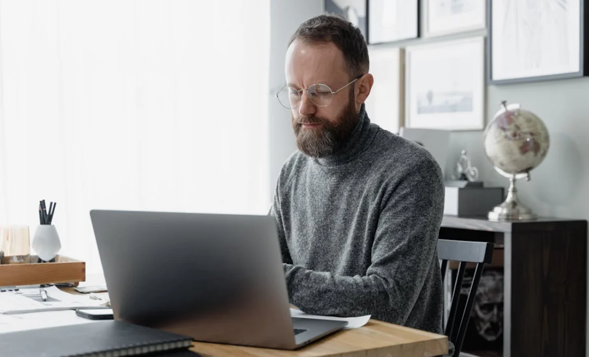 a man wearing glasses working in a office