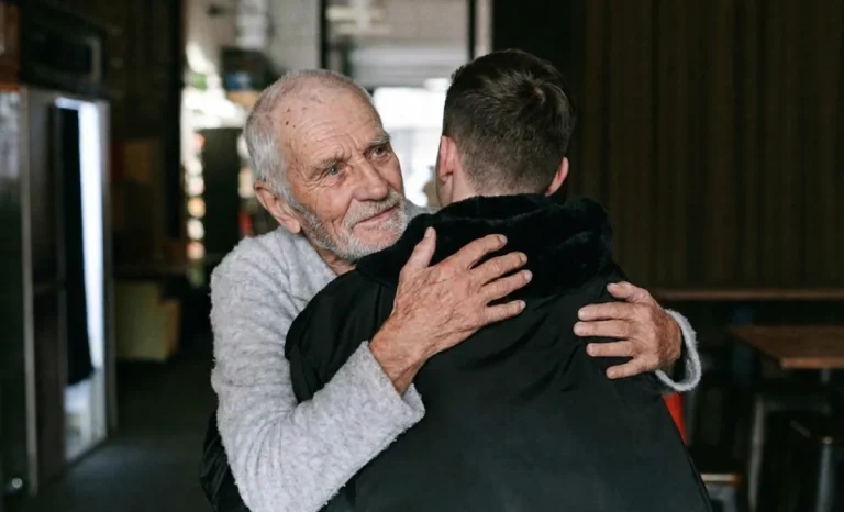 a young man hugging a senior man