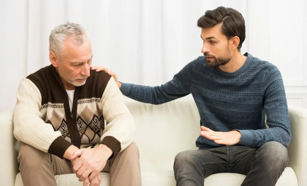 a young man patting a senior man