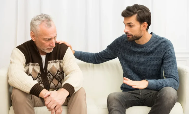 a young man patting a senior man