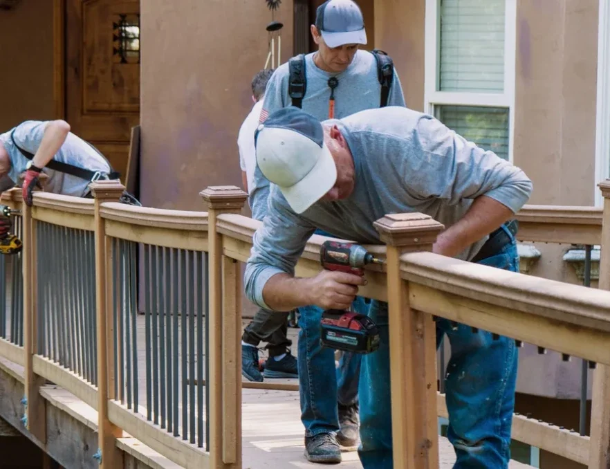 men repairing a wooden fence