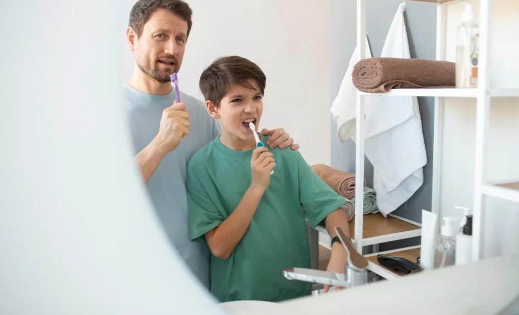 a man brushing teeth with his son