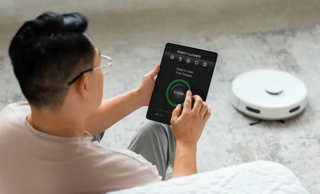 a man turning on robot cleaner through tab