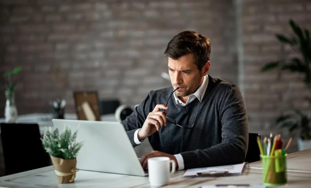 a focused man working on laptop