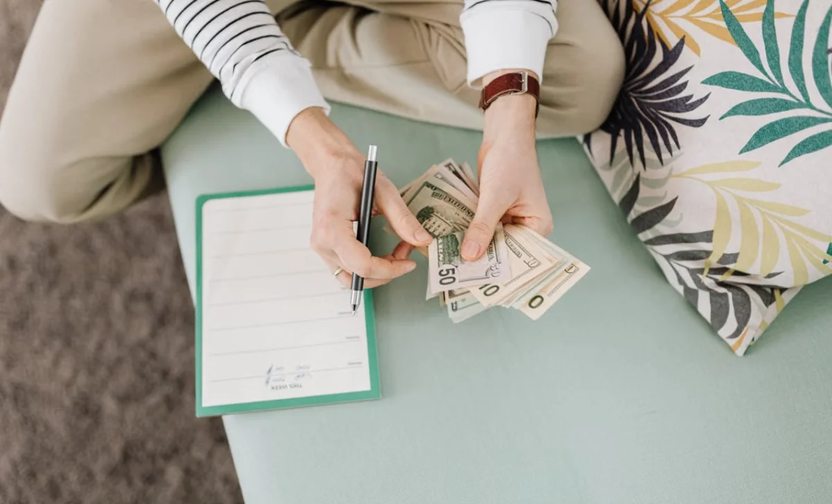 a man counting money on sofa