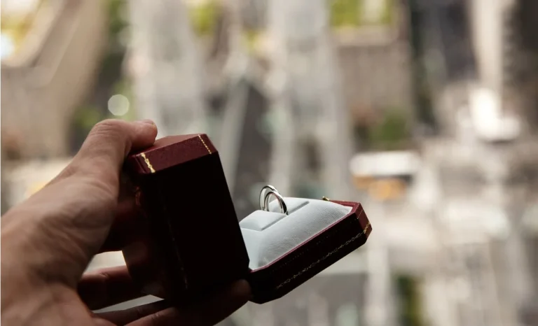man holds red box with wedding rings