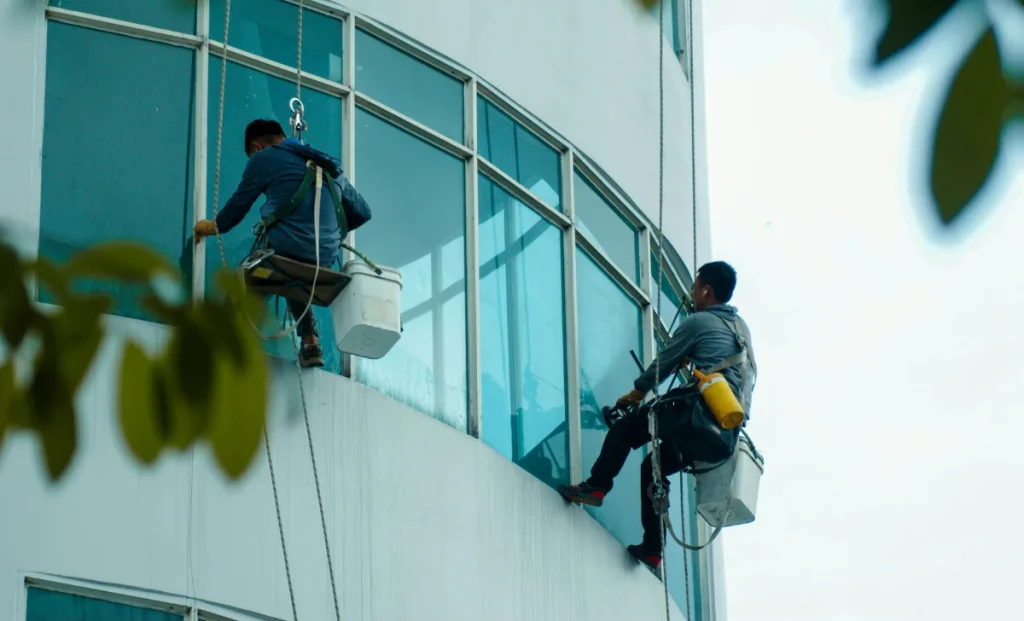 two men cleaning windows of a building
