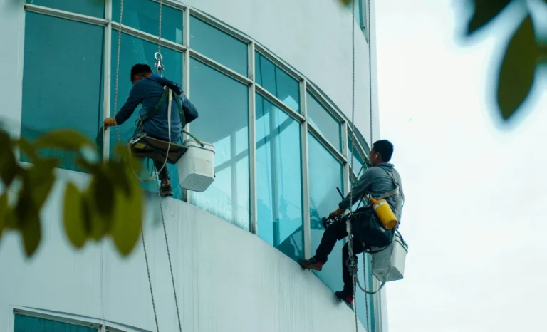 two men cleaning windows of a building