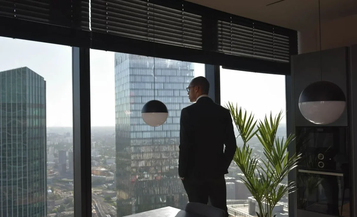 a man standing in a building with outdoor blinds